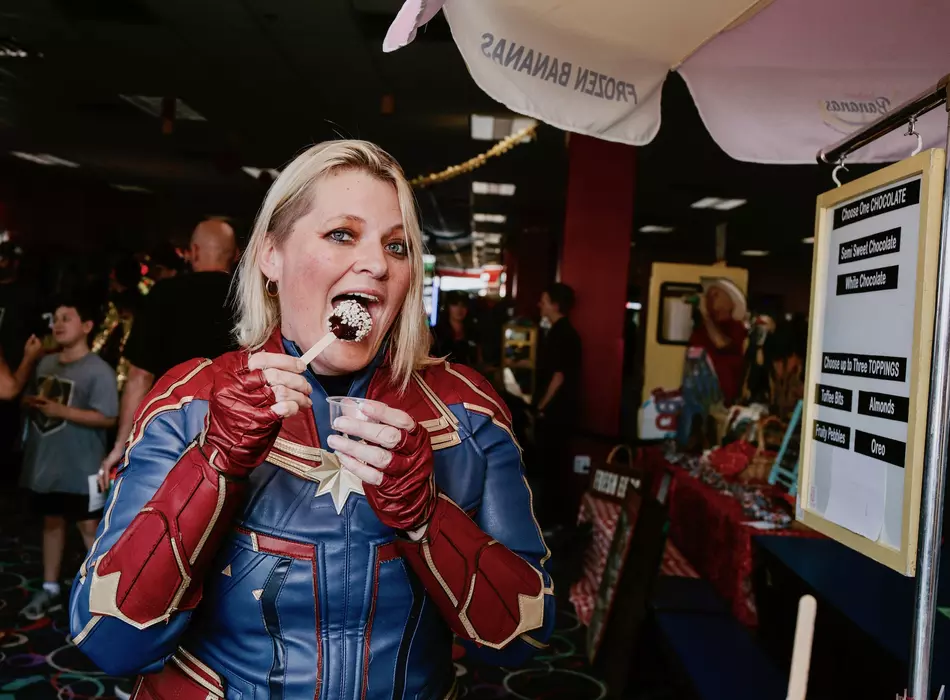 Photo of customer eating our banana pop dessert at comic con birthday event we catered to.